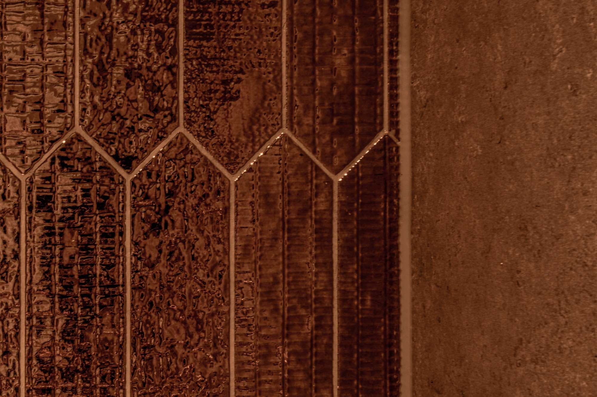 Koperkleurige wandtegels in detail in Montfoort door Keistad Tegelwerken